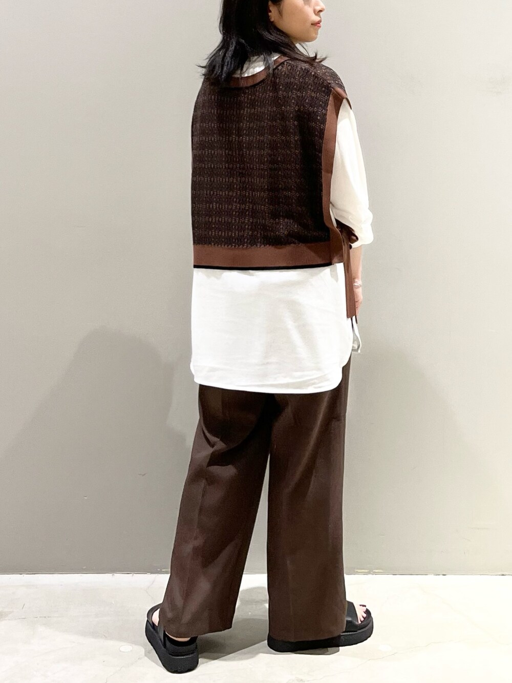 ブラウン系のスラックス、ブラック系のサンダル、ブラウン系のマタニティウェア/グッズを着用したレディースの秋コーディネートの3枚目の写真