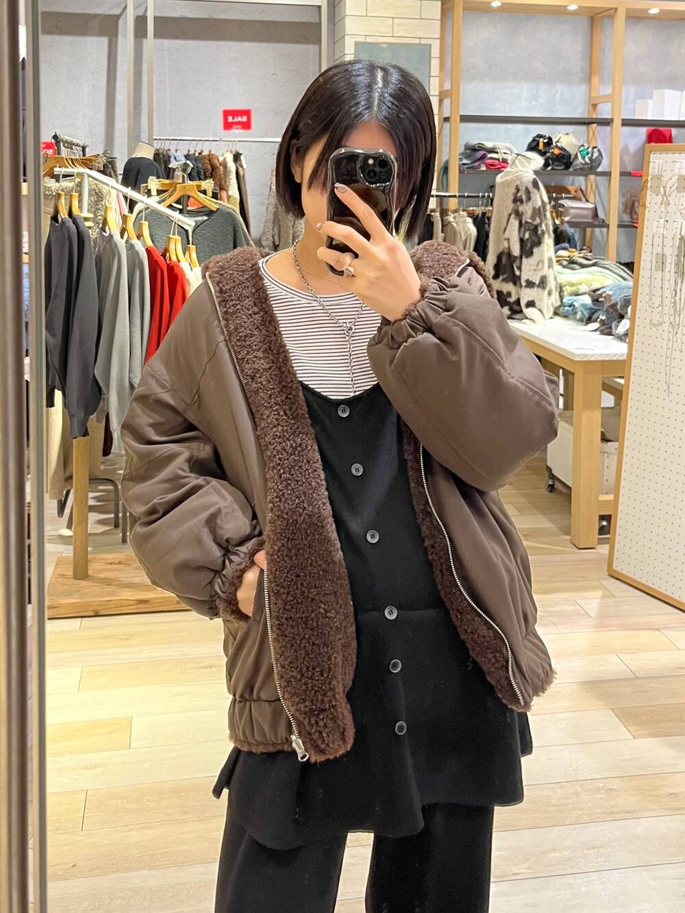 ホワイト系のTシャツ/カットソー、ブラウン系のブルゾン、ブラック系のその他シューズを着用したレディースの冬コーディネートの3枚目の写真