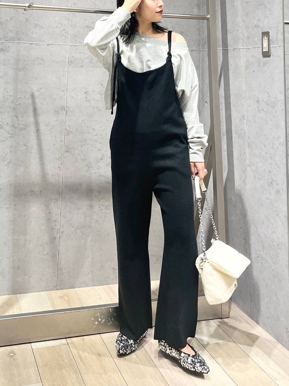 ホワイト系のショルダーバッグ、シルバー系のパンプス、グレー系のスウェットを着用したレディースの秋コーディネートの2枚目の写真