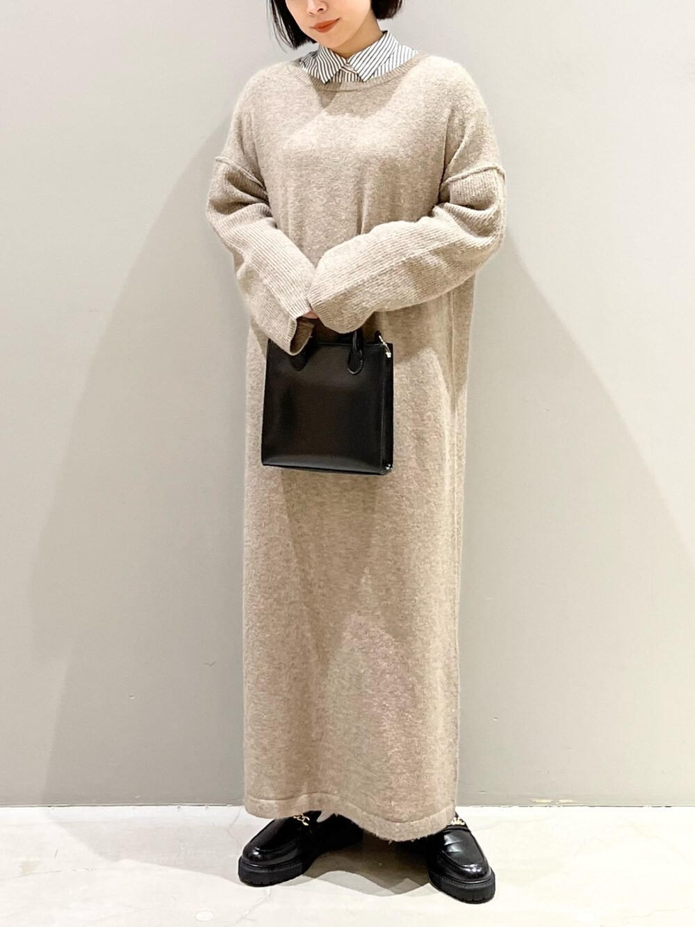 ブラック系のショルダーバッグ、ブラック系のローファー、ブラウン系のワンピースを着用したレディースの冬コーディネートの4枚目の写真