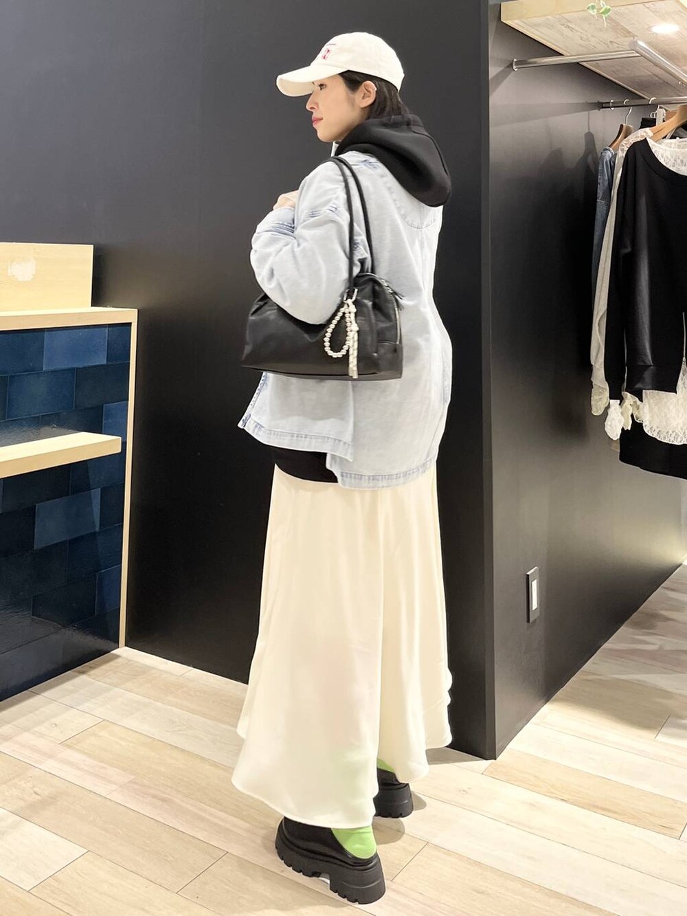 ブラック系のパーカー、ブルー系のシャツ/ブラウス、ブラック系のボストンバッグを着用したレディースの春コーディネートの3枚目の写真