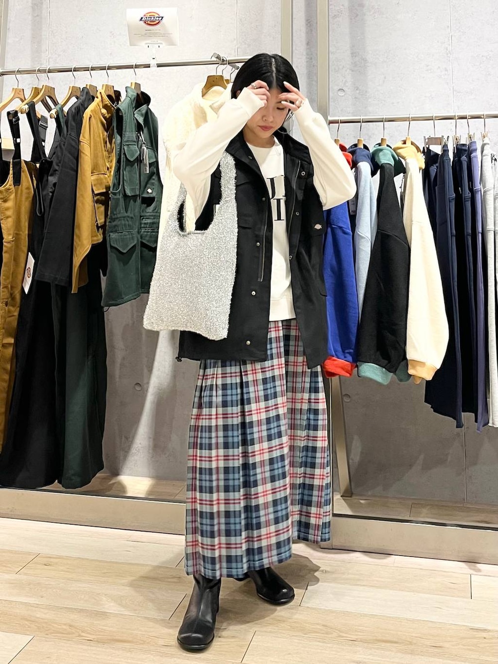 ブラック系のベスト、ホワイト系のスウェット、ブラック系のブーツを着用したレディースの秋コーディネートの7枚目の写真