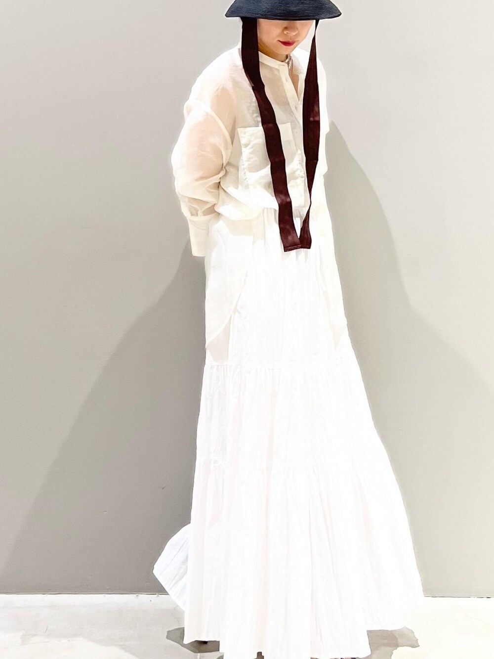 ホワイト系のスカート、ホワイト系のシャツ/ブラウス、ブラック系のサンダルを着用したレディースの夏コーディネートの8枚目の写真