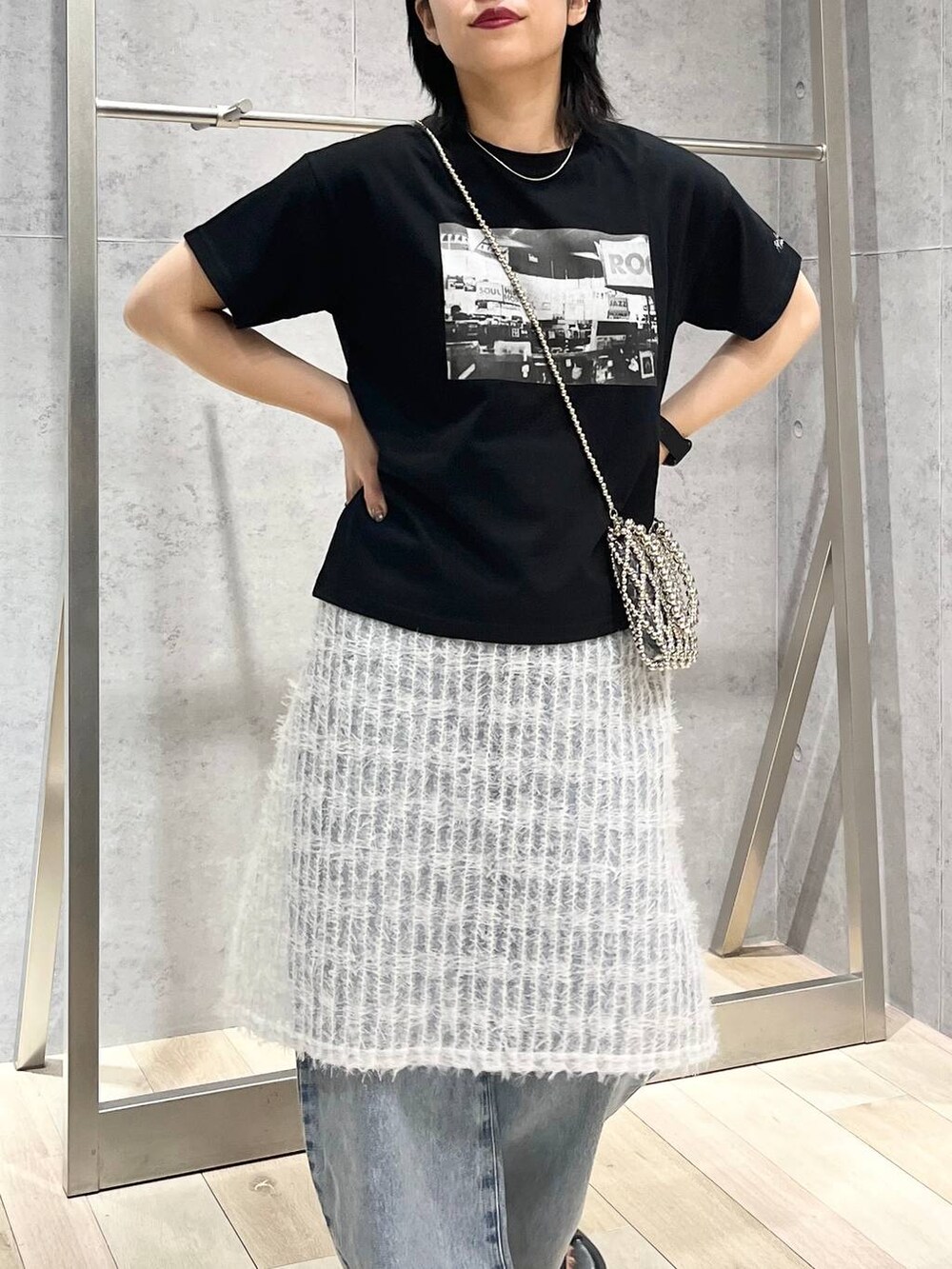 ブラック系のTシャツ/カットソー、ブラック系のサンダル、ブルー系のデニムパンツを着用したレディースの夏コーディネートの2枚目の写真