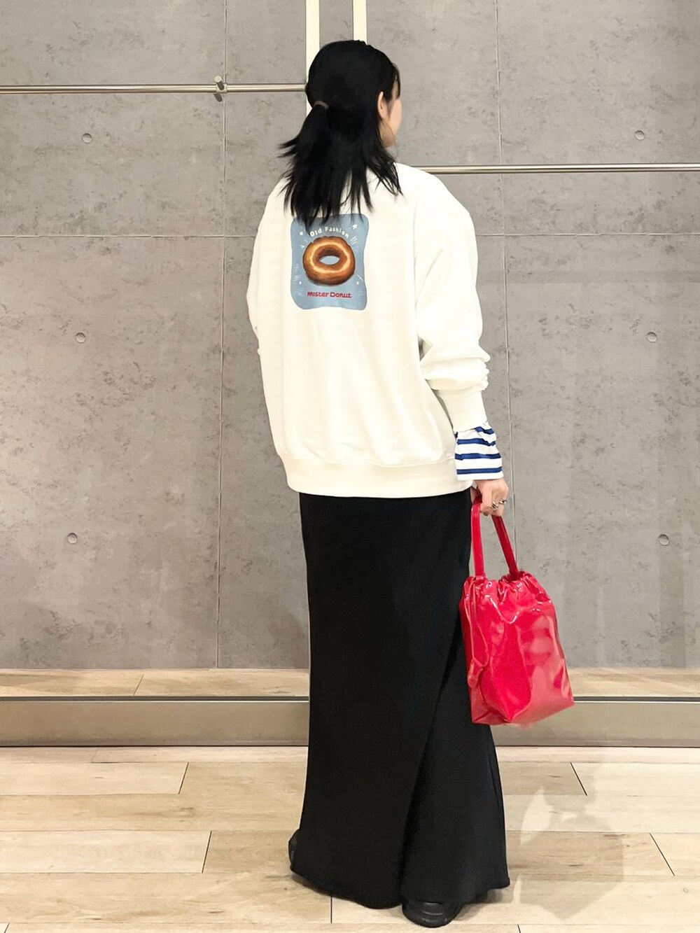 ブラック系のスカート、ブラック系のスニーカー、ホワイト系のスウェットを着用したレディースの冬コーディネートの2枚目の写真