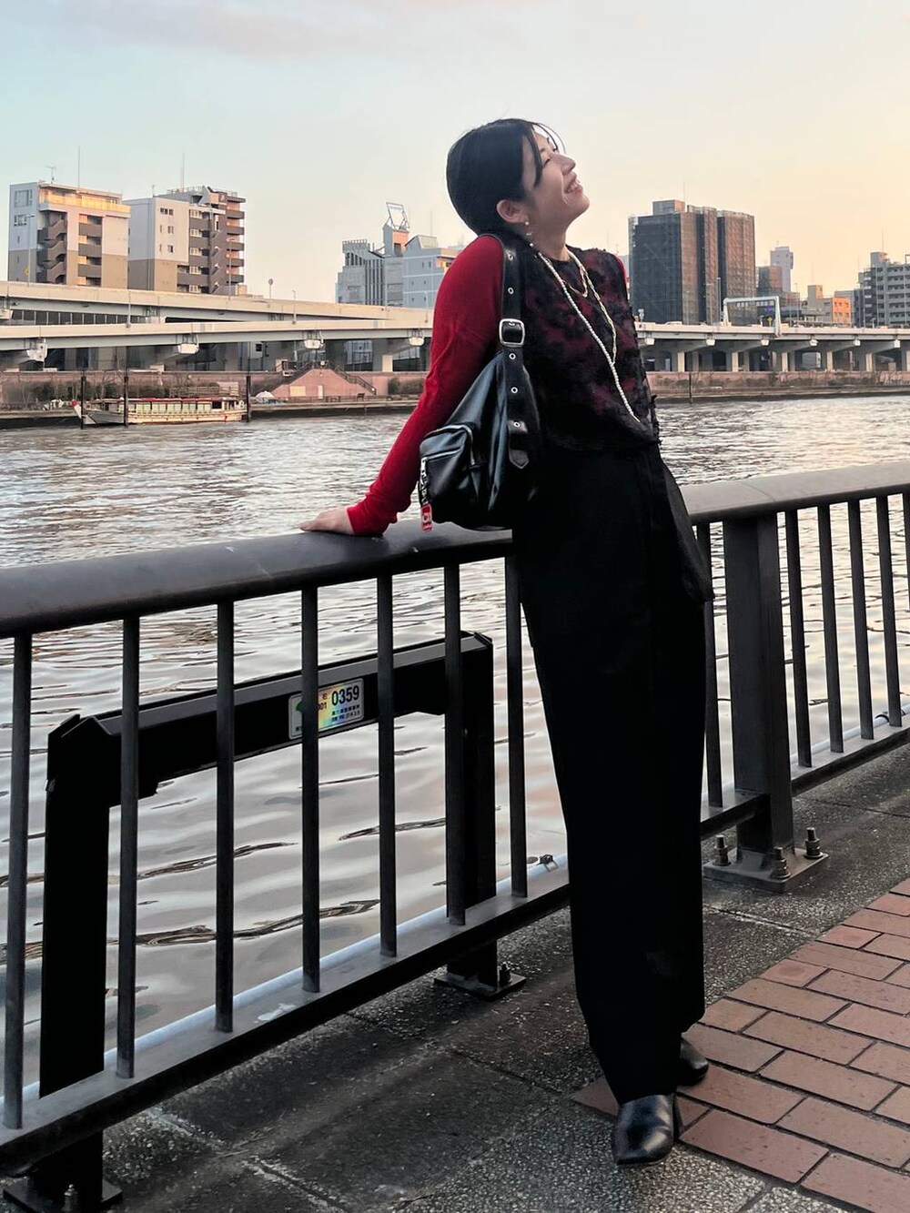 レッド系のTシャツ/カットソー、ブラック系のショルダーバッグ、ブラック系のその他パンツを着用したレディースの冬コーディネートの10枚目の写真