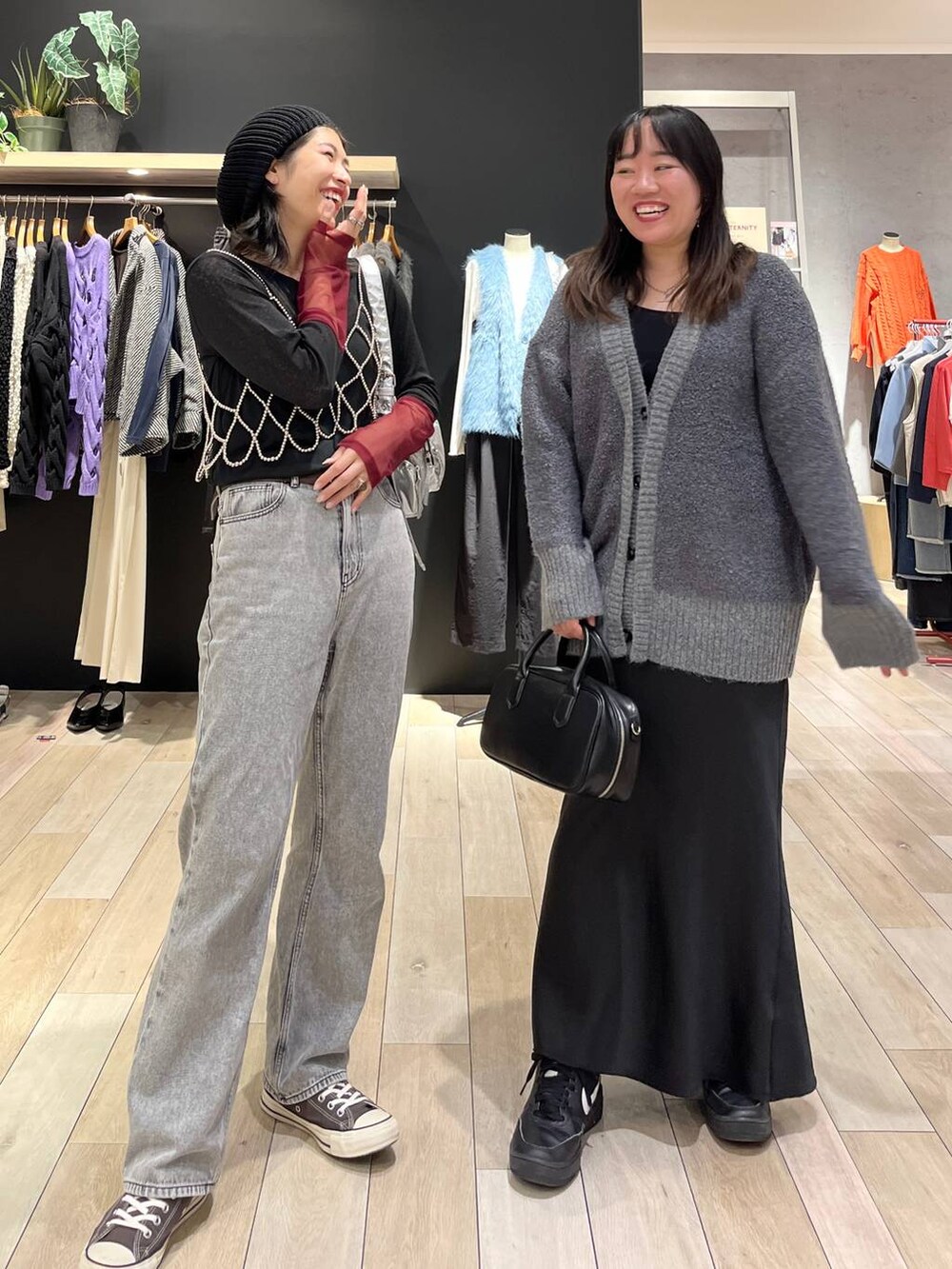 シルバー系のベスト、シルバー系のショルダーバッグ、グレー系のデニムパンツを着用したレディースの秋コーディネートの7枚目の写真