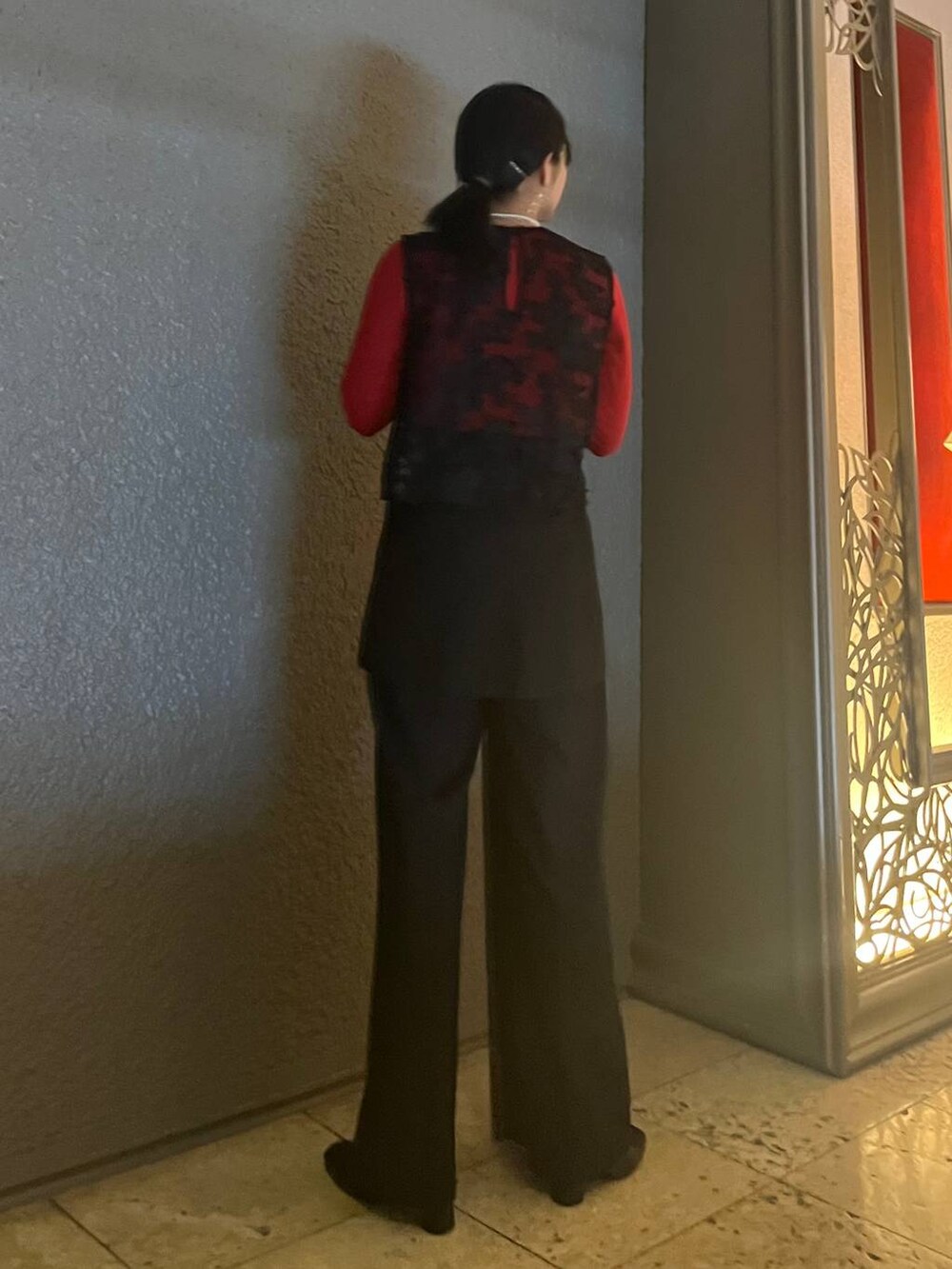 レッド系のTシャツ/カットソー、ブラック系のショルダーバッグ、ブラック系のその他パンツを着用したレディースの冬コーディネートの7枚目の写真