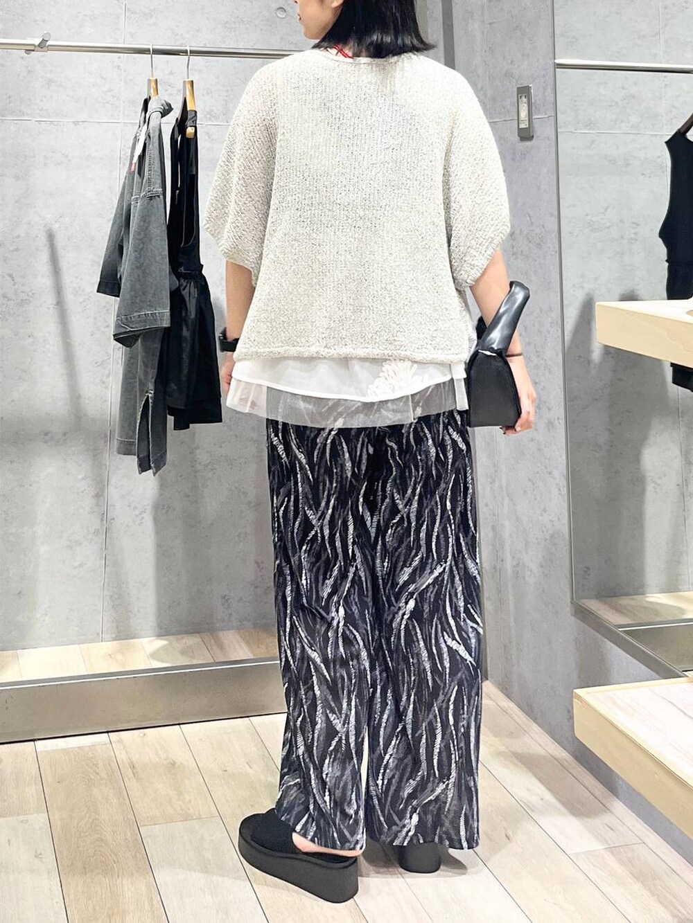 ブラック系のその他パンツ、ベージュ系のニット/セーター、ブラック系のサンダルを着用したレディースの夏コーディネートの3枚目の写真