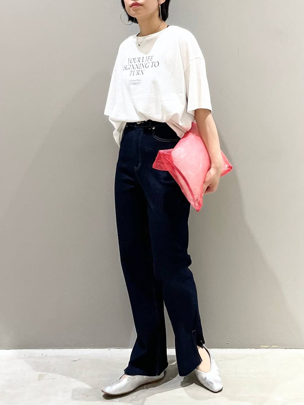 ホワイト系のTシャツ/カットソー、グレー系のパンプス、ブルー系のデニムパンツを着用したレディースの夏コーディネートの3枚目の写真