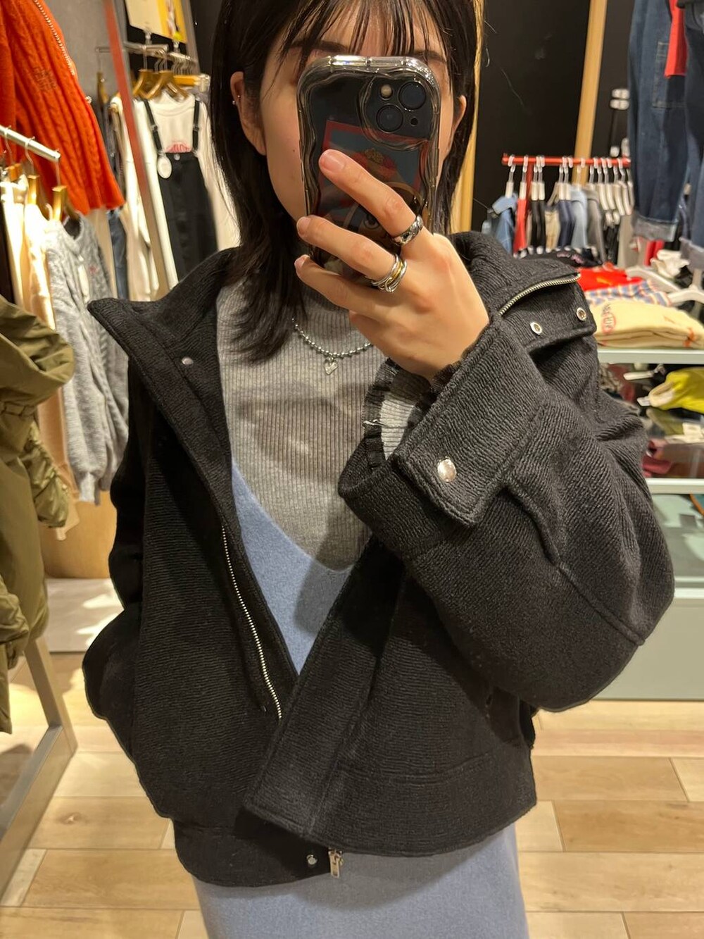 ブラック系のブルゾン、ブルー系のワンピース、ブラック系のブーツを着用したレディースの秋コーディネートの2枚目の写真