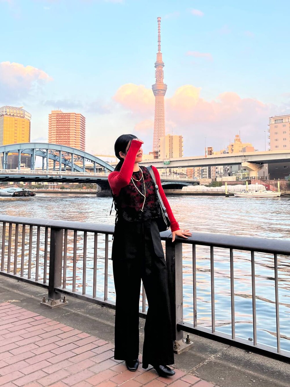 レッド系のTシャツ/カットソー、ブラック系のショルダーバッグ、ブラック系のその他パンツを着用したレディースの冬コーディネートの2枚目の写真