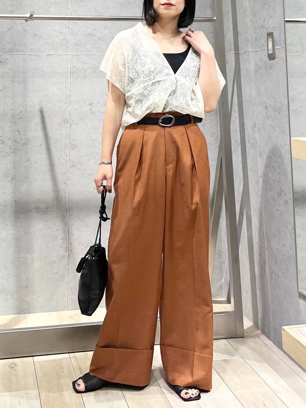 ブラック系のタンクトップ、ブラック系のサンダル、ブラック系のショルダーバッグを着用したレディースの夏コーディネートの6枚目の写真