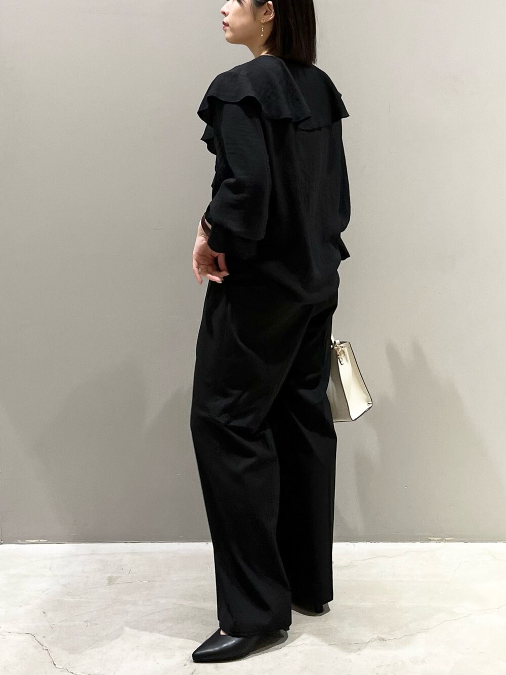 ブラック系のシャツ/ブラウス、ブラック系のバッグ、ブラック系のパンツを着用したレディースの春コーディネートの4枚目の写真