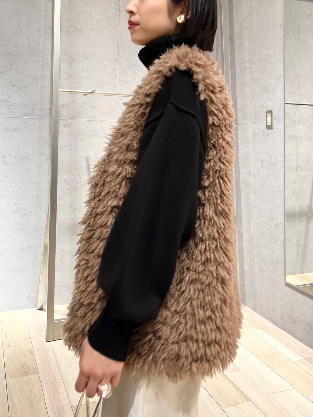 ブラック系のニット/セーター、ブラウン系のブーツ、ホワイト系のその他パンツを着用したレディースの秋コーディネートの6枚目の写真