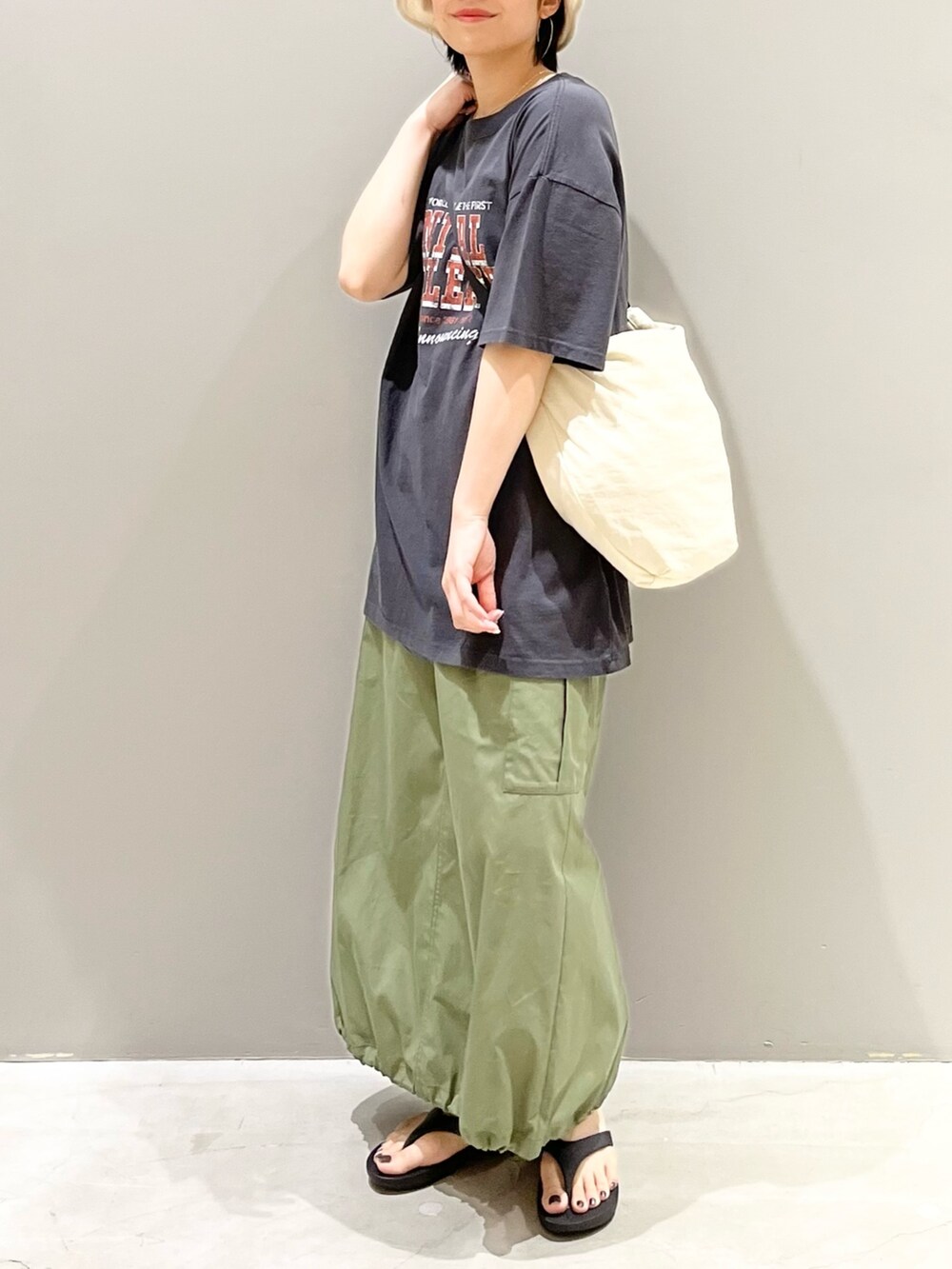 グレー系のTシャツ/カットソー、ホワイト系のショルダーバッグ、グリーン系のスカートを着用したレディースの夏コーディネートの2枚目の写真