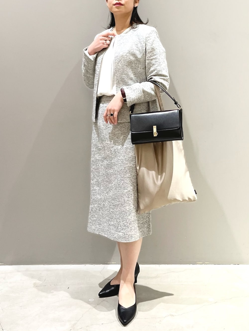 ブラック系のパンプス、ホワイト系のスーツスカート、ホワイト系のシャツ/ブラウスを着用したレディースの冬コーディネートの2枚目の写真