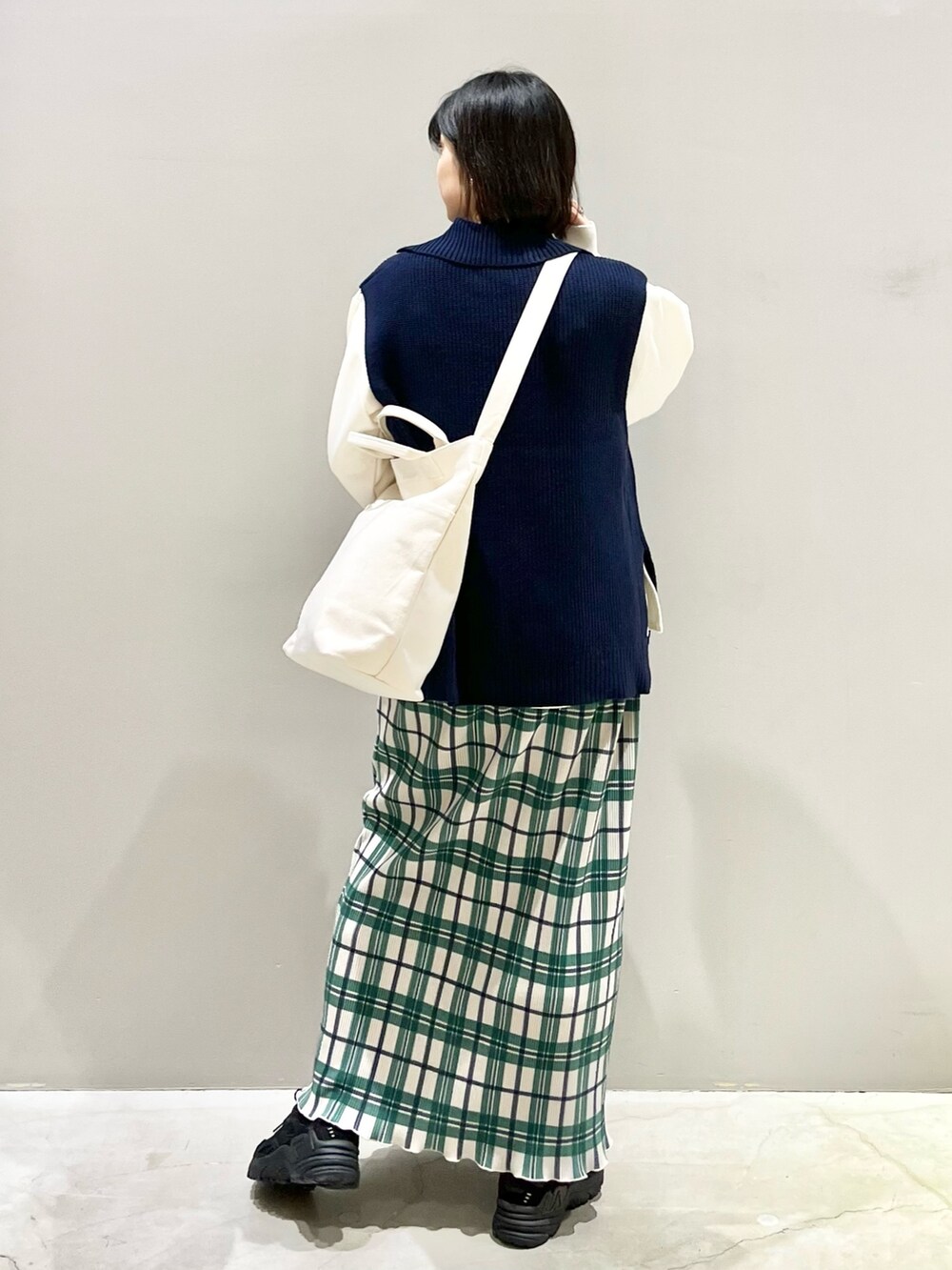 ブラック系のスニーカー、ホワイト系のスウェット、ホワイト系のショルダーバッグを着用したレディースの冬コーディネートの3枚目の写真