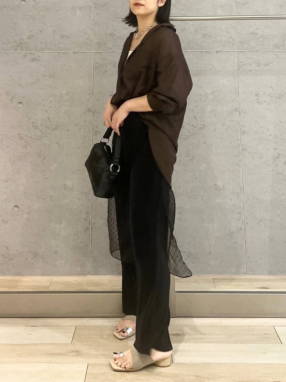 ホワイト系のタンクトップ、ブラック系のハンドバッグ、ブラック系のその他パンツを着用したレディースの夏コーディネートの4枚目の写真