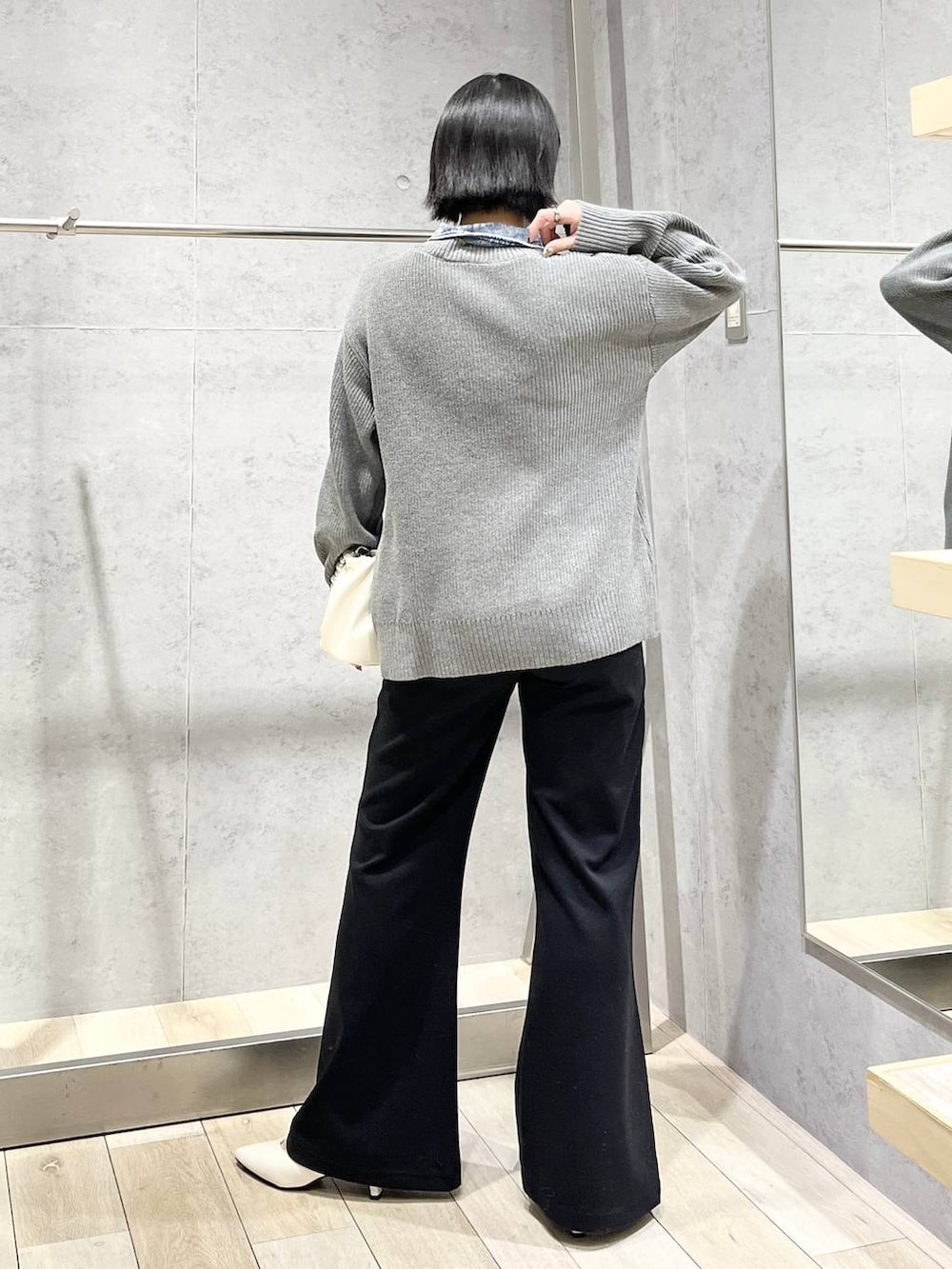 ホワイト系のパンプス、ホワイト系のショルダーバッグ、ブラック系のその他パンツを着用したレディースの冬コーディネートの6枚目の写真