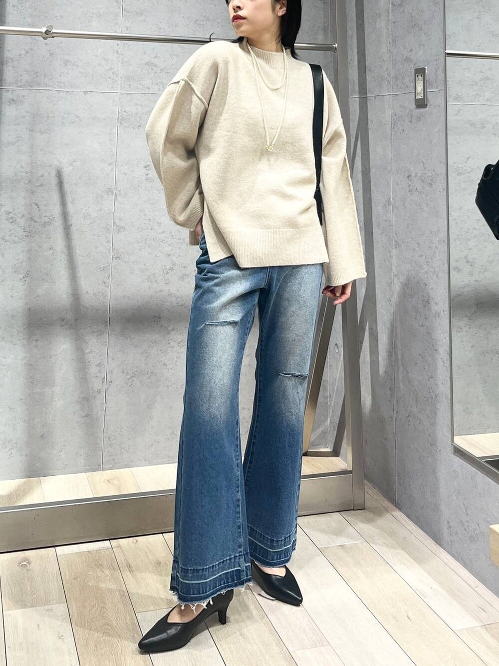 ブラック系のパンプス、ブラック系のショルダーバッグ、ベージュ系のニット/セーターを着用したレディースの冬コーディネートの5枚目の写真