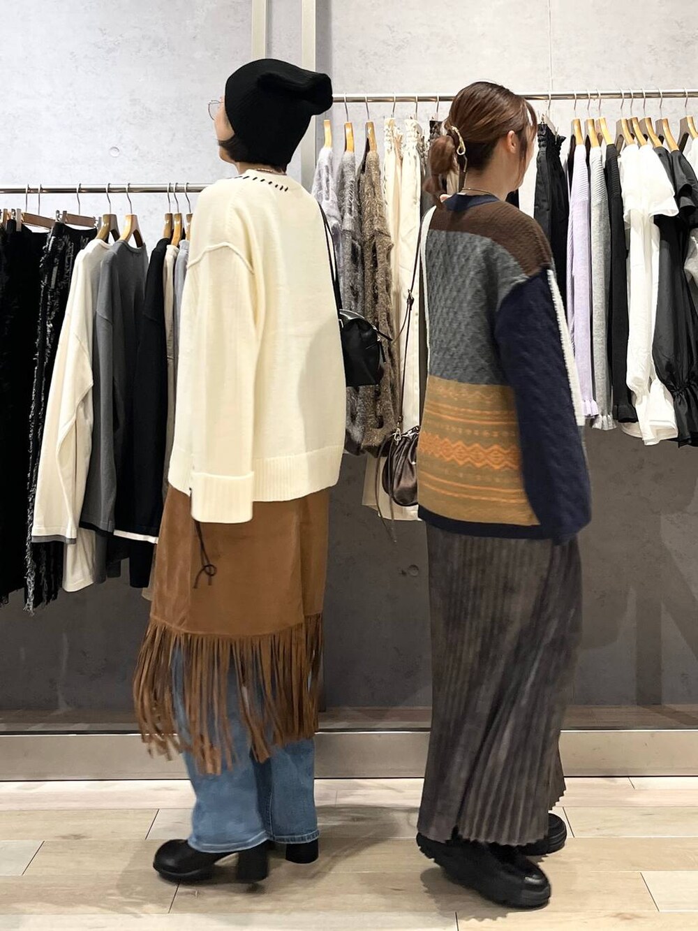 ブルー系のデニムパンツ、ブラック系のその他シューズ、グレー系のスカートを着用したレディースの秋コーディネートの2枚目の写真