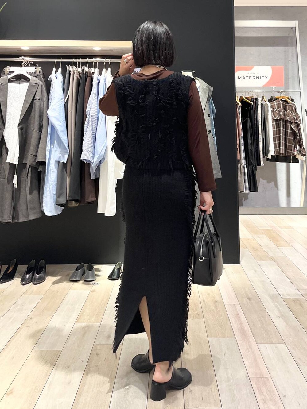 ブラック系のその他シューズ、ブラック系のボストンバッグ、ブラウン系のTシャツ/カットソーを着用したレディースの秋コーディネートの4枚目の写真