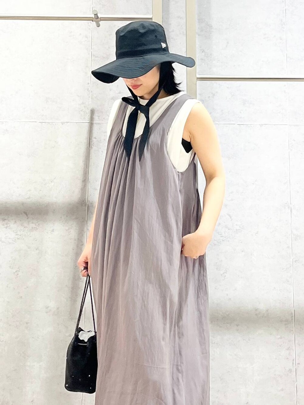 ブラック系のショルダーバッグ、ブラック系のサンダル、ホワイト系のTシャツ/カットソーを着用したレディースの夏コーディネートの6枚目の写真