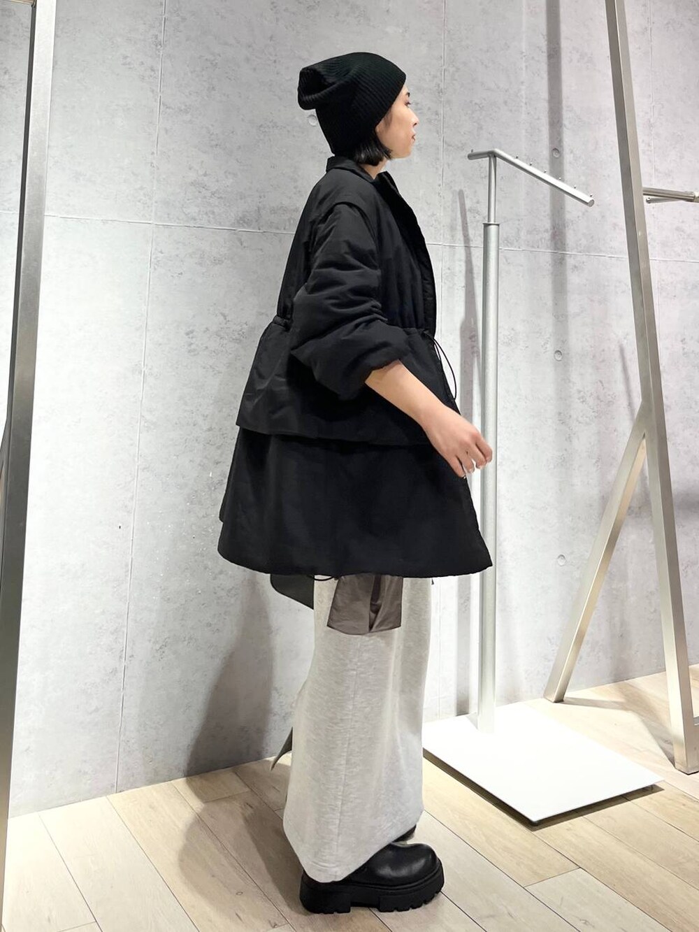 グレー系のスカート、ブラック系のボストンバッグ、ブラック系のブーツを着用したレディースの秋コーディネートの8枚目の写真