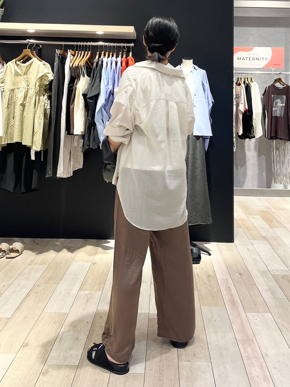 ブラック系のハンドバッグ、ブラック系のサンダル、ホワイト系のシャツ/ブラウスを着用したレディースの夏コーディネートの3枚目の写真