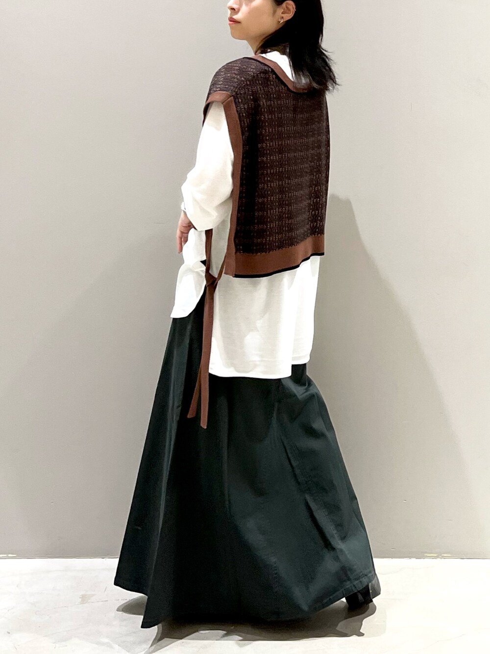 グレー系のスカート、ブラック系のパンプス、ブラウン系のマタニティウェア/グッズを着用したレディースの秋コーディネートの5枚目の写真