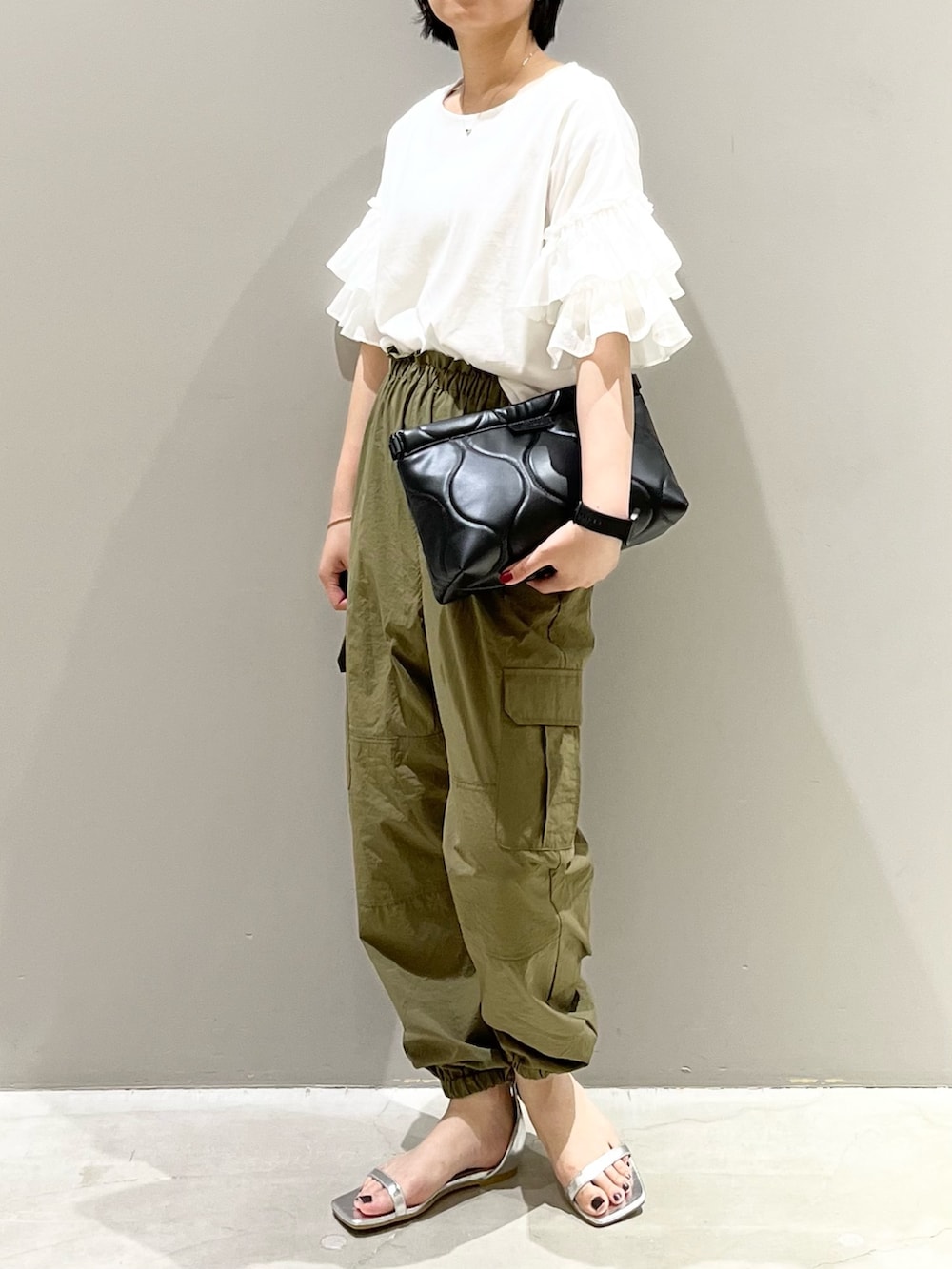 シルバー系のサンダル、ブラック系のバッグ、ホワイト系のTシャツ/カットソーを着用したレディースの秋コーディネートの2枚目の写真