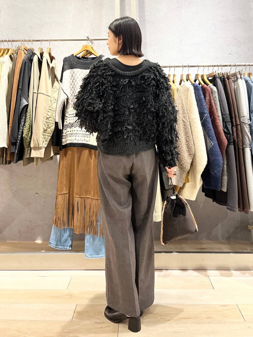 ブラック系のその他シューズ、グレー系のその他パンツ、ブラウン系のショルダーバッグを着用したレディースの秋コーディネートの4枚目の写真