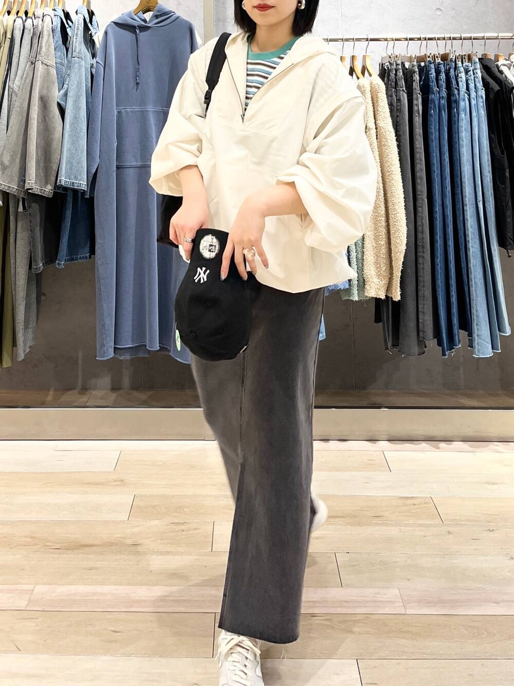 ブラック系のショルダーバッグ、ホワイト系のTシャツ/カットソー、ブラック系のスカートを着用したレディースの春コーディネートの5枚目の写真