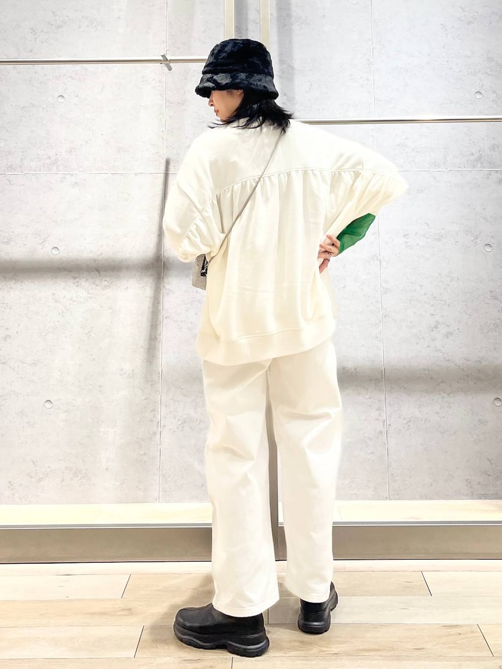 ブラック系のTシャツ/カットソー、ホワイト系のスウェット、ブラック系のブーツを着用したレディースの冬コーディネートの4枚目の写真