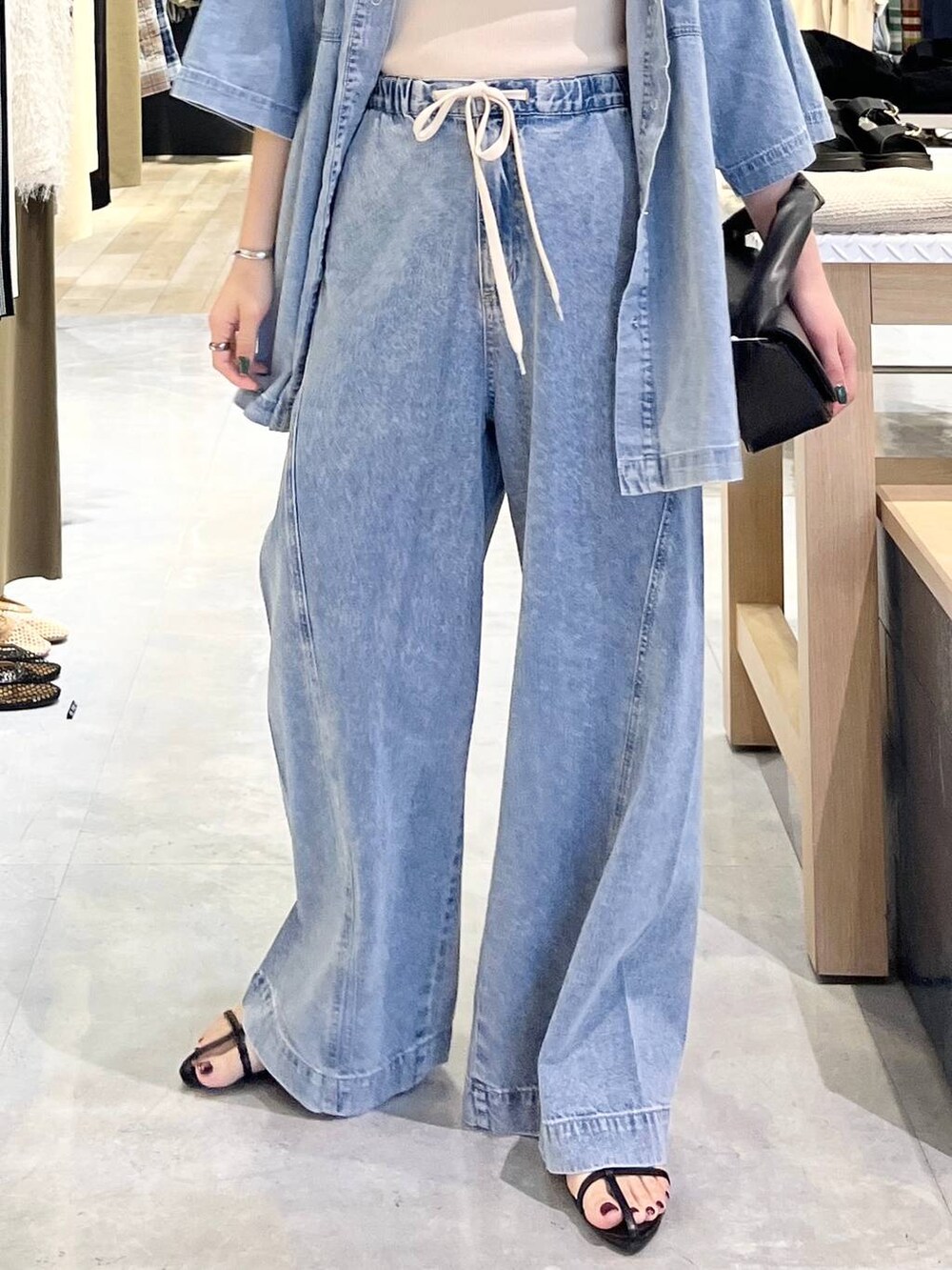 ブルー系のシャツ/ブラウス、ホワイト系のタンクトップ、ブルー系のデニムパンツを着用したレディースの春コーディネートの8枚目の写真