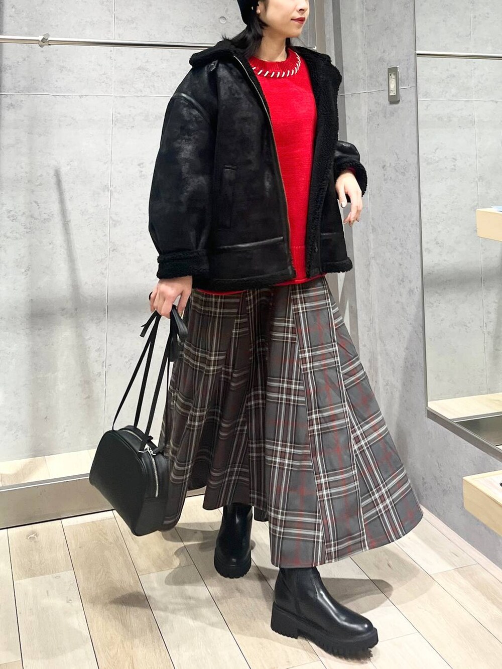 ブラック系のブーツ、ブラック系のその他アウター、グレー系のスカートを着用したレディースの冬コーディネートの2枚目の写真