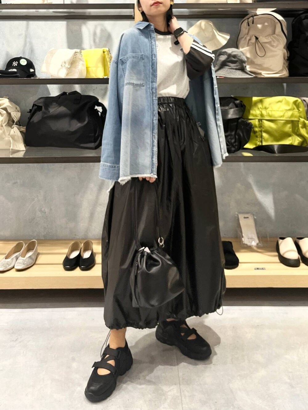 ブラック系のショルダーバッグ、ブラック系のTシャツ/カットソー、ブラック系のスニーカーを着用したレディースの春コーディネートの8枚目の写真