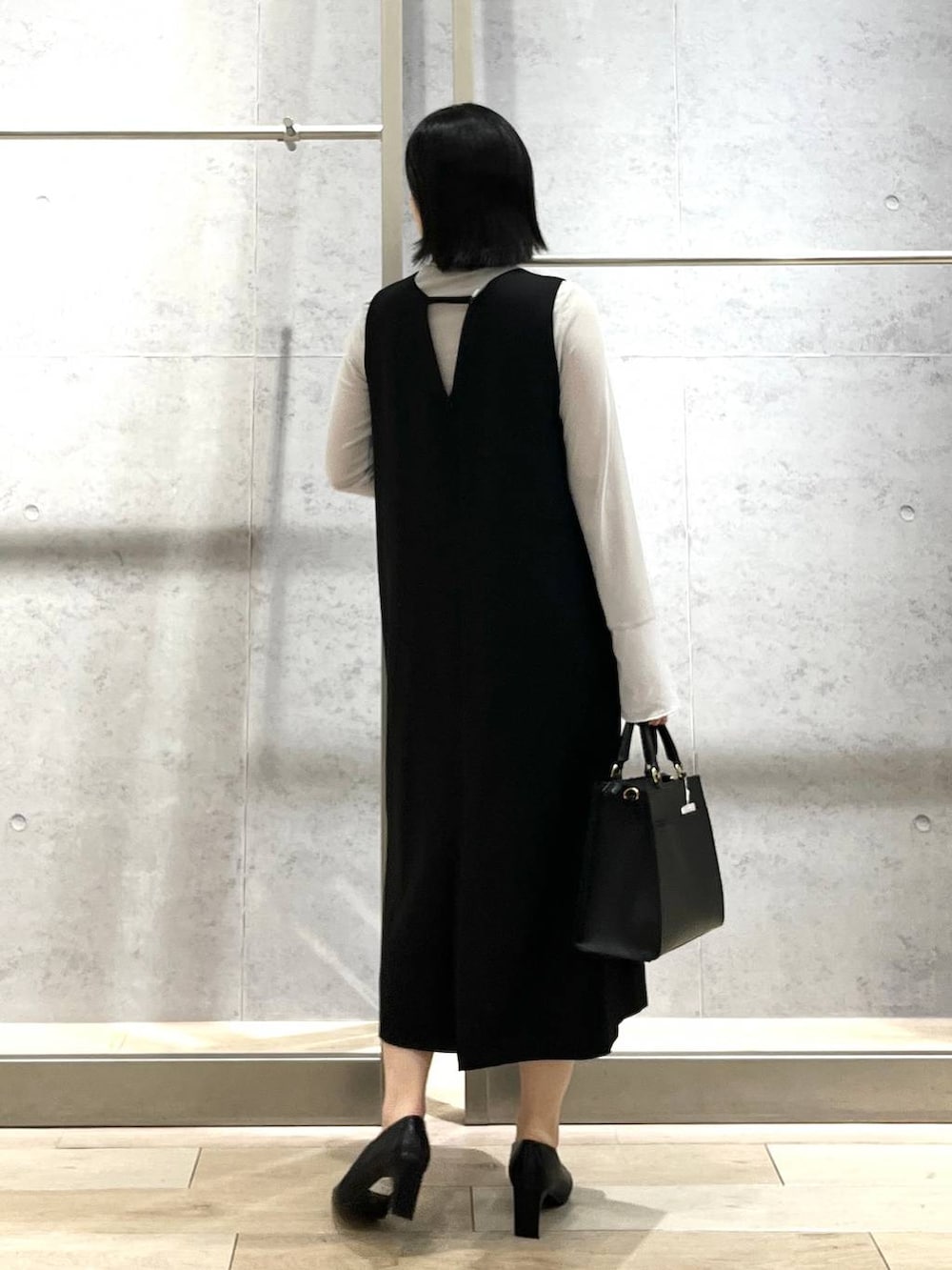 ブラック系のパンプス、グレー系のTシャツ/カットソー、ブラック系のショルダーバッグを着用したレディースの冬コーディネートの4枚目の写真