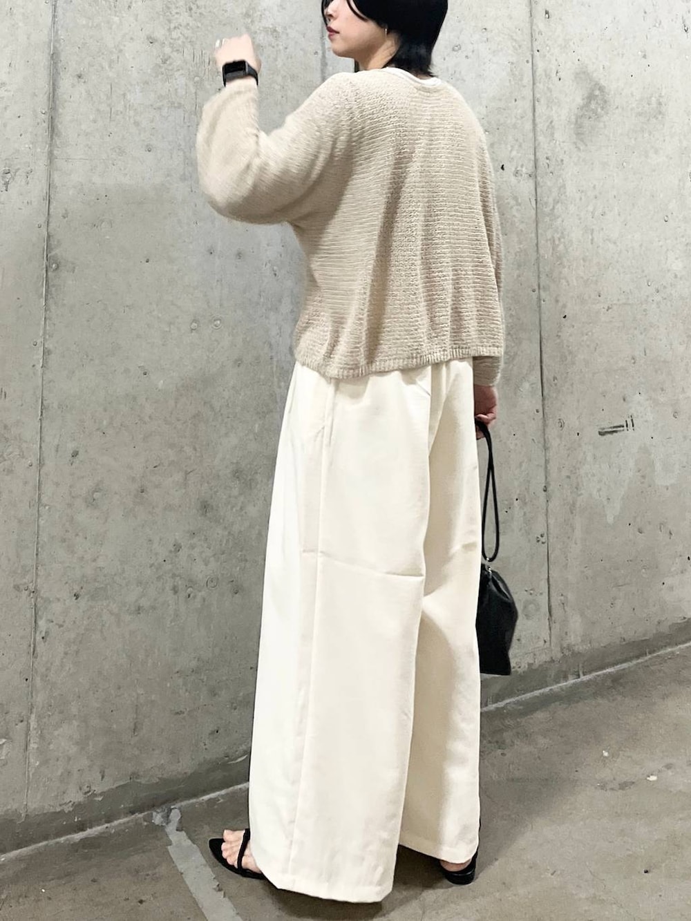 ブラック系のショルダーバッグ、ブラック系のサンダル、ホワイト系のTシャツ/カットソーを着用したレディースの春コーディネートの4枚目の写真