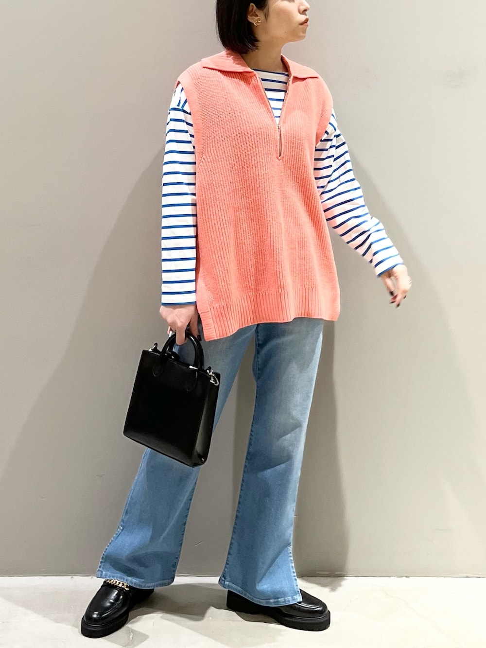 ブルー系のデニムパンツ、ブラック系のローファー、ブラック系のショルダーバッグを着用したレディースの春コーディネートの4枚目の写真