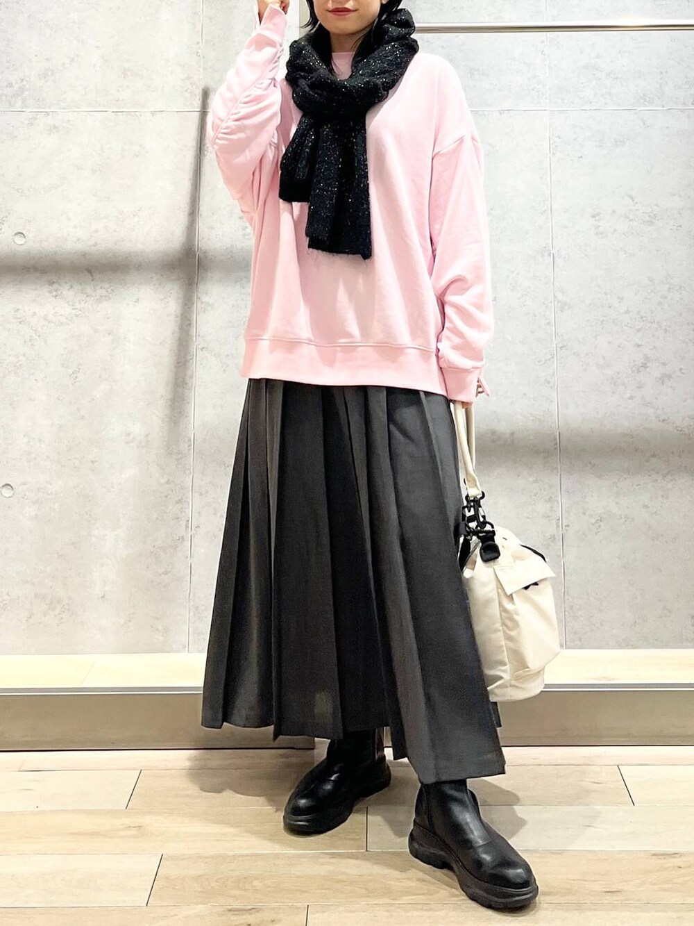 ホワイト系のショルダーバッグ、ピンク系のスウェット、ブラック系のブーツを着用したレディースの秋コーディネートの9枚目の写真