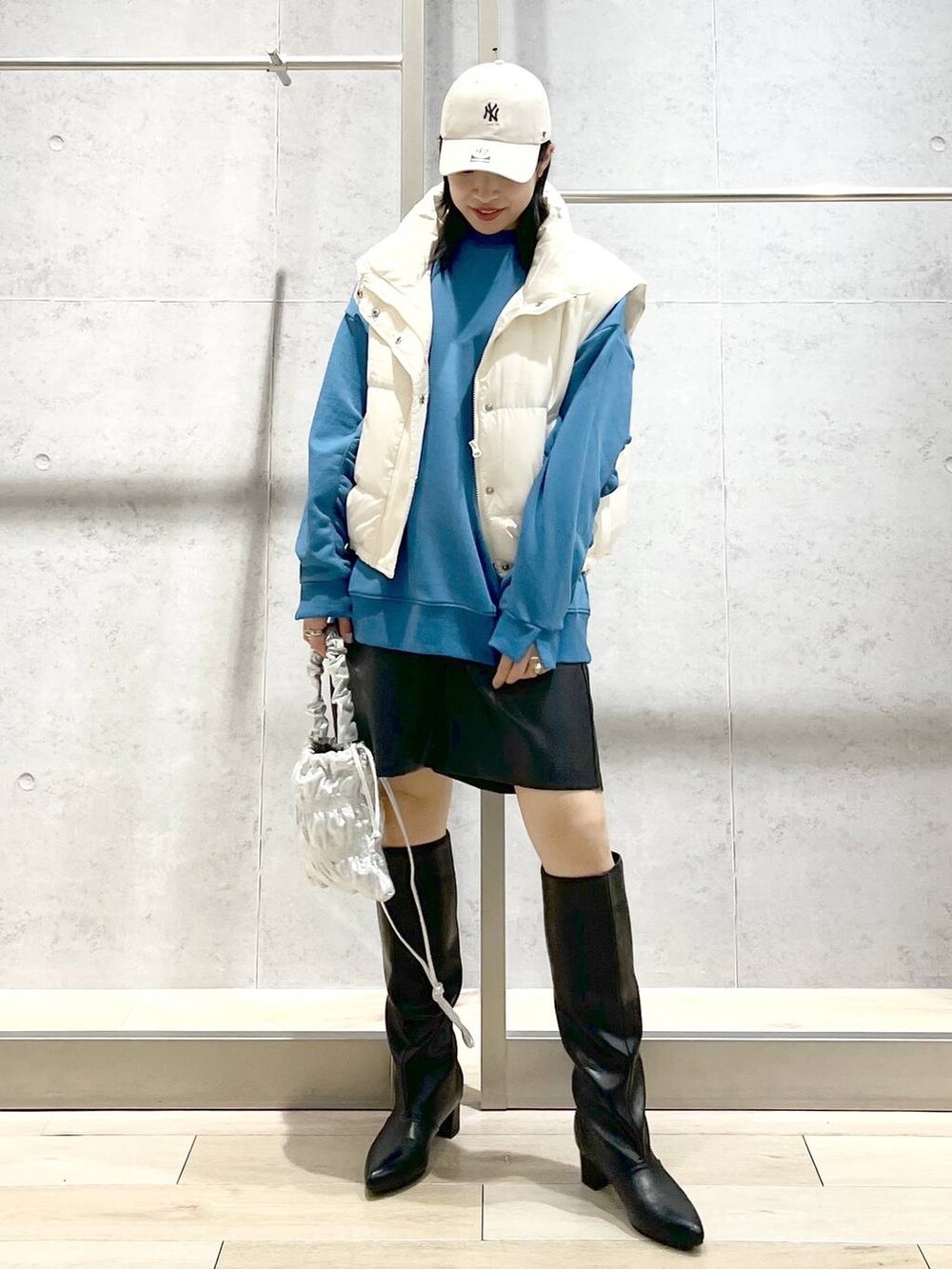 ホワイト系のダウンベスト、シルバー系のショルダーバッグ、ブラック系のその他パンツを着用したレディースの冬コーディネートの7枚目の写真