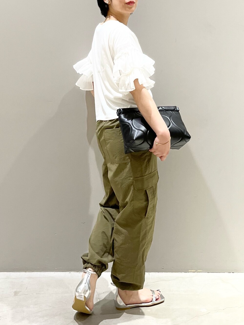 シルバー系のサンダル、ブラック系のバッグ、ホワイト系のTシャツ/カットソーを着用したレディースの秋コーディネートの6枚目の写真