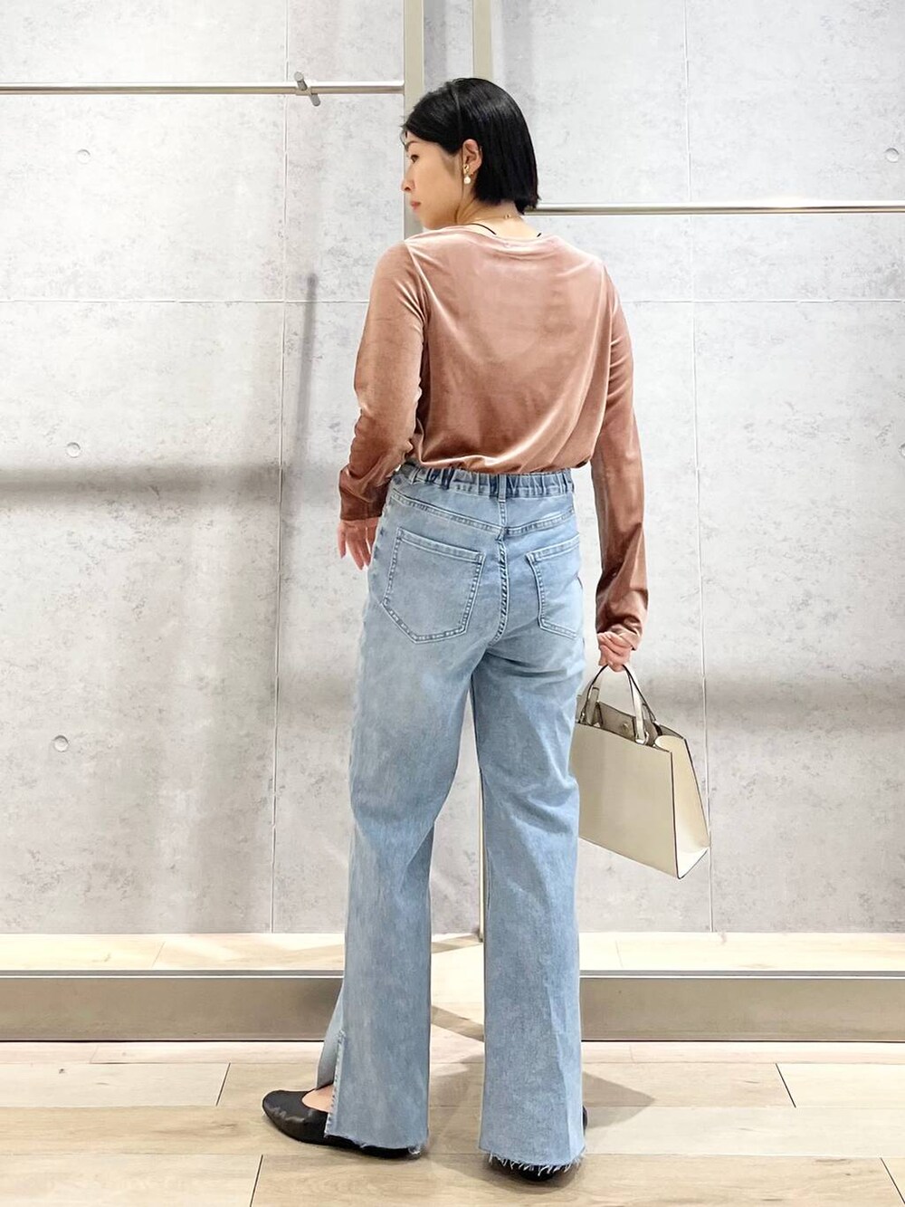 ブラック系のパンプス、ブルー系のデニムパンツ、ホワイト系のショルダーバッグを着用したレディースの秋コーディネートの6枚目の写真