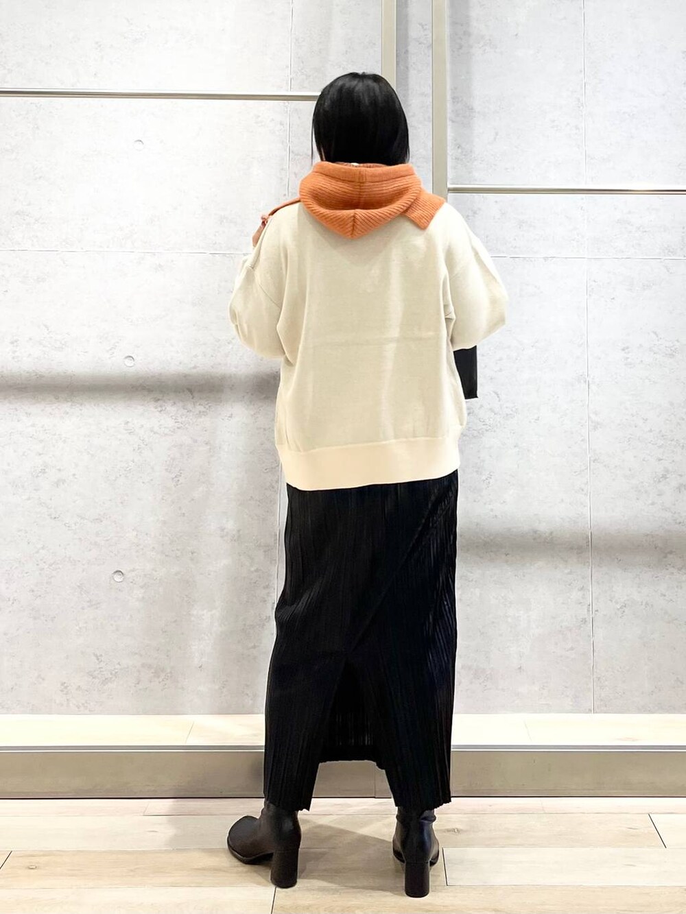 ブラック系のショルダーバッグ、ブラック系のブーツ、ホワイト系のニット/セーターを着用したレディースの秋コーディネートの5枚目の写真