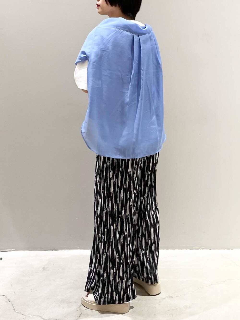 ブラック系のその他パンツ、ベージュ系のサンダル、ホワイト系のTシャツ/カットソーを着用したレディースの春コーディネートの4枚目の写真