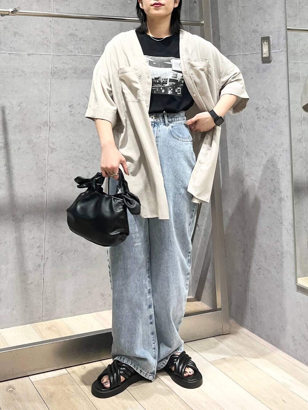 ブラック系のTシャツ/カットソー、ブラック系のサンダル、ブルー系のデニムパンツを着用したレディースの夏コーディネートの2枚目の写真