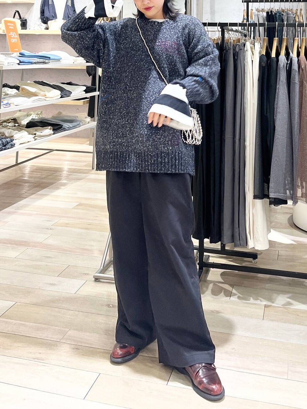 シルバー系のショルダーバッグ、グレー系のチノパンツ、ブラック系のTシャツ/カットソーを着用したレディースの秋コーディネートの3枚目の写真