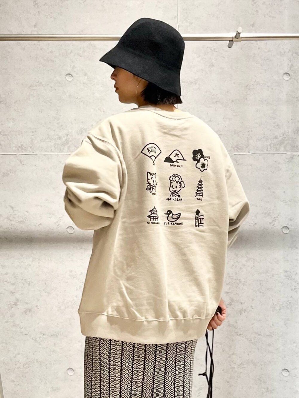 ブラック系のスカート、シルバー系のショルダーバッグ、ブラック系のブーツを着用したレディースの冬コーディネートの5枚目の写真